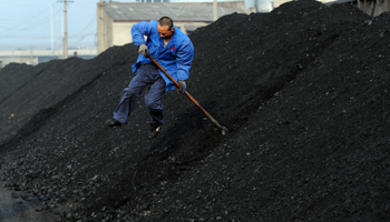 A worker shovels coal at a freight yard in Hefei (REUTERS/Stringer)