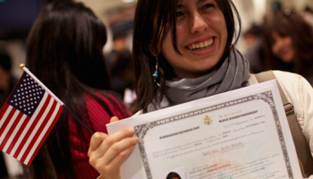 A new US citizen poses with her certificate during a ceremony in San Francisco (REUTERS/Robert Galbraith)