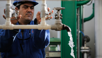 A worker checks water levels in a diesel tank at an oil refinery (REUTERS/Desmond Boylan)