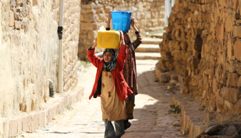 A girl helps her mother fetch water in Sana'a (REUTERS/Mohamed al-Sayaghi)