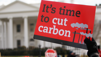 A demonstrator holds up a sign during a march past the White House to protest against the Keystone XL pipeline (REUTERS/Richard Clement)