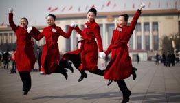 Hotel guides for delegates jump for a photograph during the opening ceremony of the National People's Congress in Beijing (REUTERS/Carlos Barria)