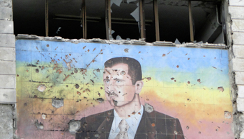A picture of Syria's President Bashar al-Assad on the facade of the police academy in Aleppo, after it was captured by Free Syrian Army fighters (REUTERS/Mahmoud Hassano)