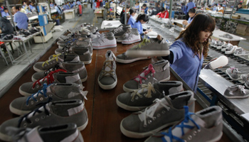 Employees work on an assembly line at a shoe factory in Vietnam (REUTERS/Kham)