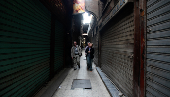 Tourists walk in front of rows of closed shops at a market in Old Cairo (REUTERS/Amr Abdallah Dalsh)