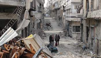 Men stand on a street lined with buildings damaged by what activists said was shelling (REUTERS/Mohamed Ibrahim/Shaam News Network/Handout)