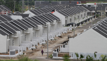 A worker walks among new residential complex under developed in Jakarta, Indonesia (REUTERS/Supri)