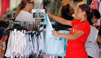 Female vendor shows a t-shirt inside a shop in Rio de Janeiro  (REUTERS/Sergio Moraes)