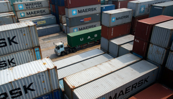 A truck drives past containers at a port in Ningbo, China (Reuters/William Hong)