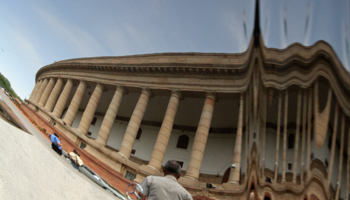 The parliament building in New Delhi is reflected on a car (Reuters/B Mathur)