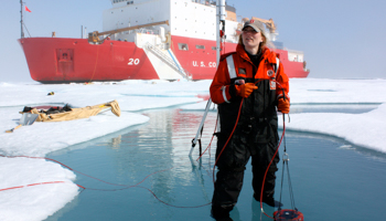 A scientist takes optical measurements in a melt pond in the Arctic Ocean (Reuters/Kathryn Hansen/NASA)