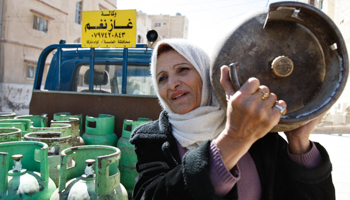 A woman delivers cooking gas cylinders in Amman (Reuters/Ali Jarekji)