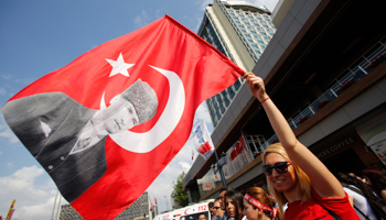 A demonstrator waves a flag with a portrait of Mustafa Kemal Ataturk in Taksim Square (Reuters/Murad Sezer)