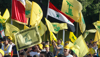 The Syrian flag is seen as people watch Hezbollah leader Hassan Nasrallah during a live broadcast (Reuters/Sharif Karim)