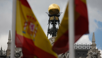 The dome of the Bank of Spain is seen between Spanish flags in central Madrid (Reuters/Sergio Perez)