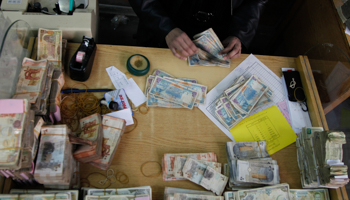 A central bank employee counts Syrian pound notes (Reuters/Khaled al-Hariri)