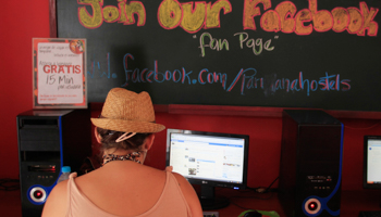 A woman uses Facebook at a backpacker hostel (Reuters/Pilar Olivares)