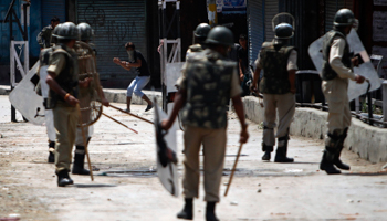 A Kashmiri Muslim youth reacts after throwing a stone towards Indian security personnel (Reuters/Danish Ismail)