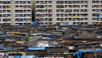 High rise residential buildings are seen behind a slum in Mumbai (Reuters/Danish Siddiqui)