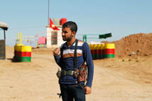 An officer of the Syrian Kurdish Democratic Union Party stands guard near the Syrian-Iraq border (Reuters/Thaier al-Sudani)