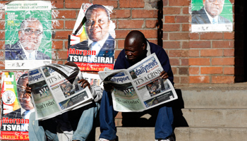 Locals read newspapers in a township outside Harare (Reuters/Siphiwe Sibeko)