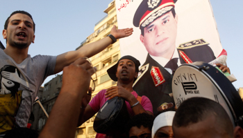 Protesters cheer near a poster of army chief Abdel Fattah El-Sisi (Reuters/Asmaa Waguih)