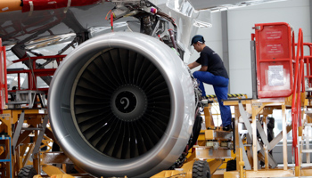 An employee installs an engine for an A320 plane under construction (Reuters/Jason Lee)