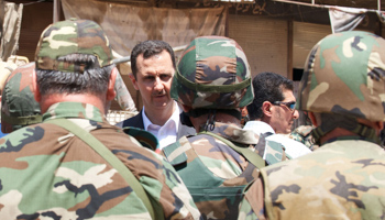 President Bashar al-Assad talks to military personnel (Reuters/SANA/Handout via Reuters)