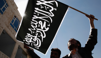 Protesters wave a flag as they demonstrate to denounce air strikes by US drones (Reuters/Khaled Abdullah)