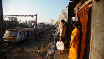 A train passes through slums in Mumbai (Reuters/Navesh Chitrakar)