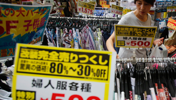A woman looks at clothes at a local shopping street in Tokyo (Reuters/Yuya Shino)