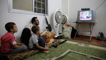 A Free Syrian Army fighter watches US President Barack Obama's speech with his family (Reuters/Mohamed Abdullah)