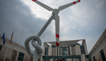 A mock wind turbine with a knotted stem is seen during a protest outside the Chancellery in Berlin (Reuters/Thomas Peter)