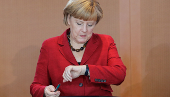 German Chancellor Angela Merkel looks at her watch as she arrives for the weekly cabinet meeting (Reuters/Tobias Schwarz)