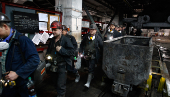 Miners walk towards a mine shaft elevator (Reuters/Peter Andrews)