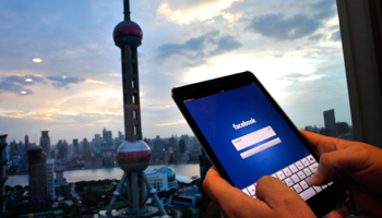 A man holds an iPad in the Pudong financial district in Shanghai (Reuters/Carlos Barria)