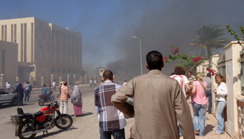 Residents and tourists watch as smoke rises near a state security building after a blast in South Sinai (Reuters/Stringer)