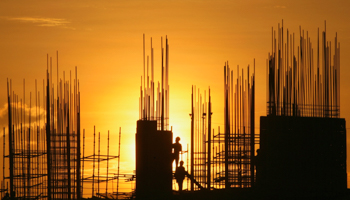 Labourers are silhouetted against the setting sun as they work in the Indian city of Hyderabad (Reuters/Krishnendu Halder)