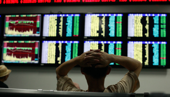 An investor reads information displayed on an electronic screen at a brokerage house in Shanghai (Reuters/Aly Song)