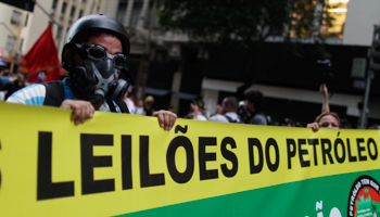 Anti-government demonstrators hold a banner as they walk towards the Petrobras' headquarters in Rio de Janeiro (Reuters/Pilar Olivares) 
	
	