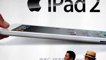 Men walk past an advertisement for Apple's iPad2 in Tokyo (Reuters/Kim Kyung-Hoon)