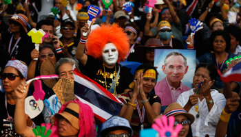 Protesters wave flags and hold a picture of Thailand's King in central Bangkok (Reuters/Damir Sagolj)