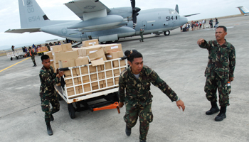 Military personnel deliver aid supplies at the destroyed airport after super typhoon Haiyan battered Tacloban City (Reuters/Edgar Su)