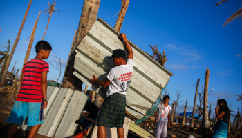 Survivors of Typhoon Haiyan carry materials (Reuters/Athit Perawongmetha)