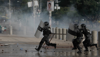 Riot police officers charge toward students during a protest in Honduras (Reuters/Jorge Cabrera )