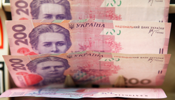 A cashier counts Ukrainian hryvnia banknotes in Kiev (Reuters/Konstantin Chernichkin)