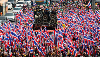 Anti-government protesters hold Thai national flags as they march towards the Department of Special Investigation (Reuters/Kerek Wongsa)