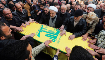 Hezbollah members and relatives pray around the coffin of Adnan Awale (Reuters/Hasan Shaaban)