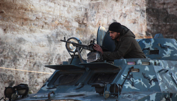 A member of al-Jabha al-Islamiya (the Islamic Front) takes position on a armoured vehicle (Reuters/Fadi Mashan)