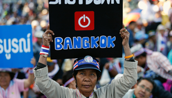 An anti-government protester joins others blocking the road in central Bangkok (Reuters/Athit Perawongmetha)